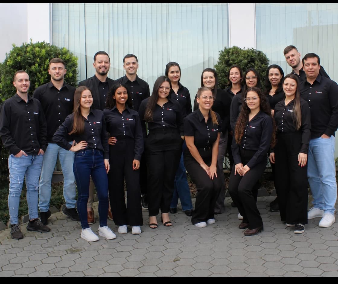 Equipe da Avilacont reunida, de uniforme, na entrada do escritório