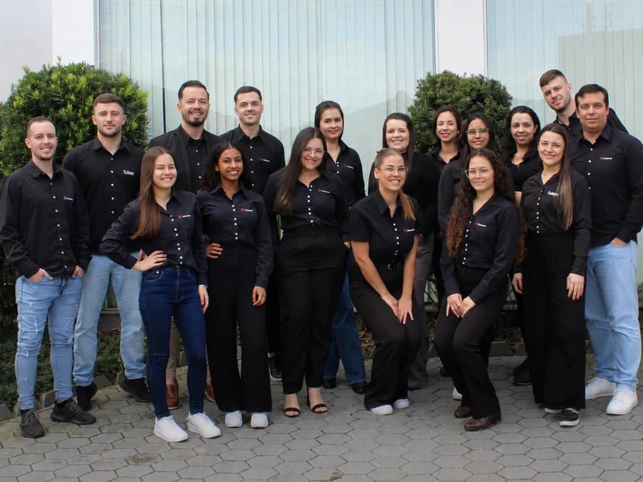 Equipe da Avilacont reunida, de uniforme, na entrada do escritório